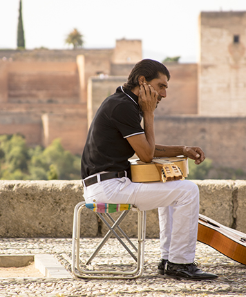Alhambra y guitarrista flamenco en el mirador de San Nicolás en el barrio del Albaicín Granada