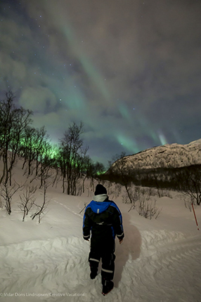 yo de espaldas enfundada en mono térmico bajo la aurora