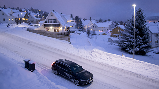 Mucha nieve en Tromso, carretera, tejados, árboles, contenedores, coches.