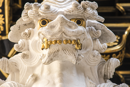 detalle escultura león blanco con ojos y dientes dorados