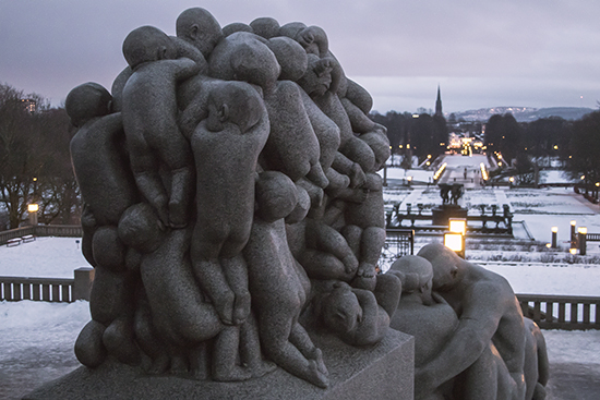 Detalle escultura granito, paisaje nevado al fonfo. Oslo.