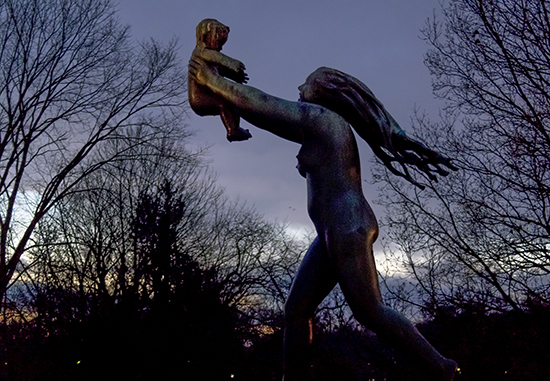escultura granito mujer feliz jugando con un niño