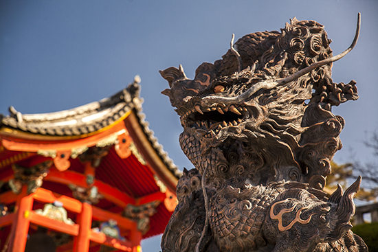detalle dragón en piedra, al fondo pagoda roja de madera. Tokio 