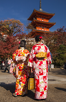 pagoda roja y turistas vestidas con kimono en Tokio