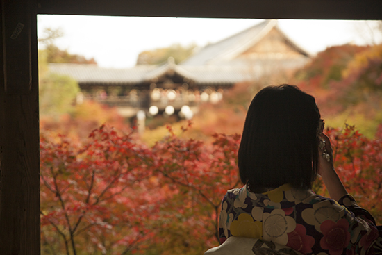 chica de espalda con kimono enmarcada por el templo y los arces rojos 